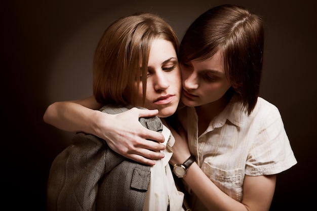 Two young woman over black background