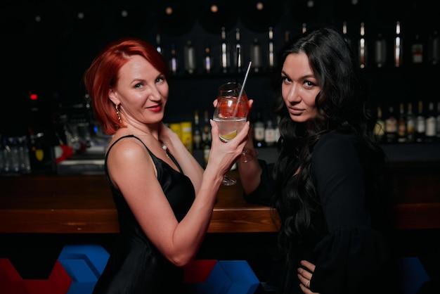 Two young women having fun in busy bar