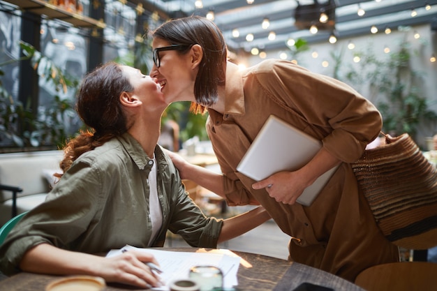 Two Young Women Meeting in Cafe