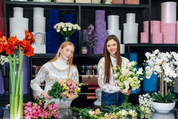 Two young women take orders by phone and make a beautiful festive bouquet