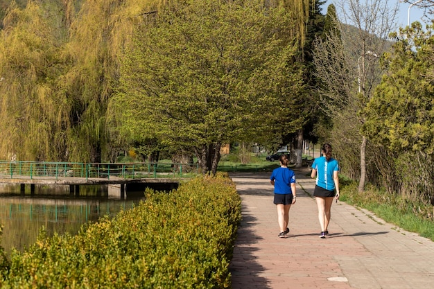 Two young women walking along the path near the city lake in Dilijan Armenia