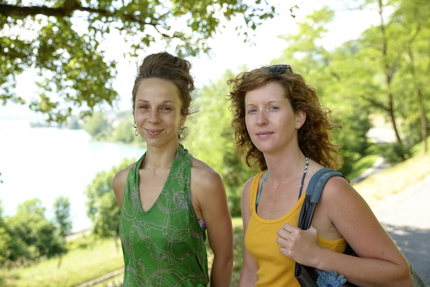 Two young women walking by the lake