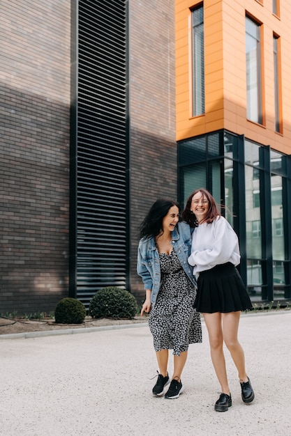 Two young women walking down the street laughing