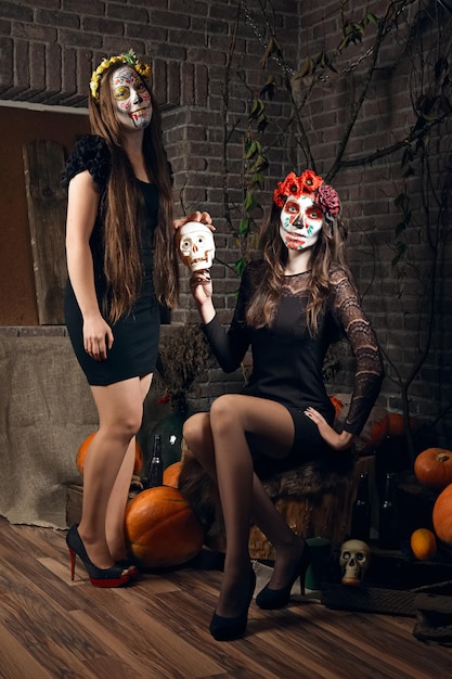 Two young women with sugar skull makeup on Halloween location