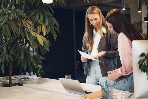 Two young women working together in office