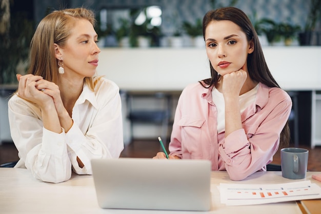 Two young women working together in office