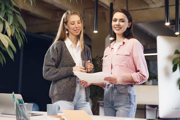 Two young women working together in office