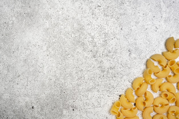 Types of uncooked pasta. Pasta chifferi dry on light concrete background. Shooting from above. Flat lay, top view, copy space