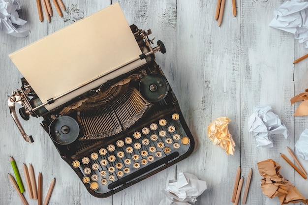 Typewriter with paper and pencils