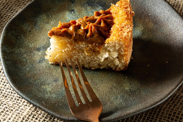 Typical brazilian churros cake with dulce de leche on a table with plates and coffee