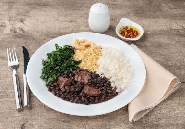 Typical brazilian feijoada with rice pepper farofa kale and cracklings