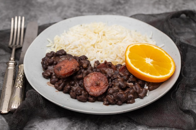 Typical brazilian food beans with sausages and rice Feijoada on white dish