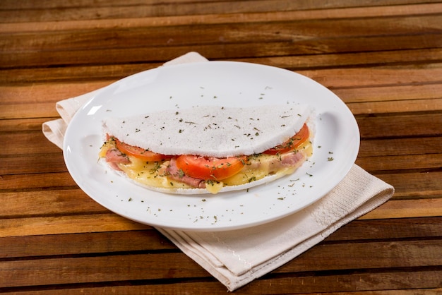 Typical Brazilian tapioca food with cheese, ham, tomato and oregano filling.