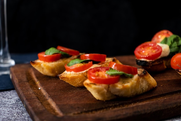 Typical Italian bruschetta or Spanish tapa with cherry tomato basil and Philadelphia type spreadable cheese Mediterranean food concept