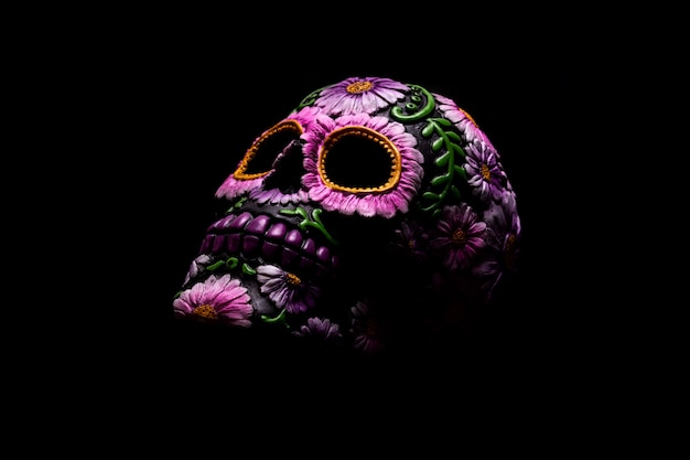 Typical Mexican skull with flowers painted on black background. Dia de los muertos.