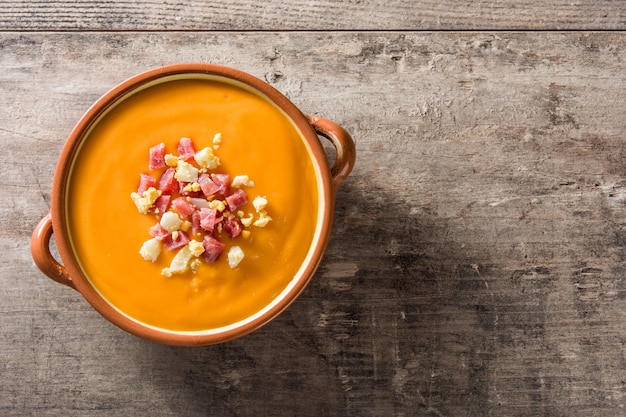 Typical Spanish salmorejo cream with ham and egg on wooden table Top view Copyspace