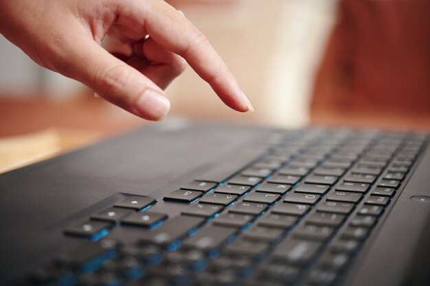 Photo typing on black keyboard with blue backlighting