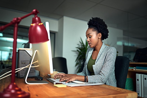 Photo typing computer and black woman in office for research with creative project online for startup career technology and african female copywriting editor working on web design on pc in workplace