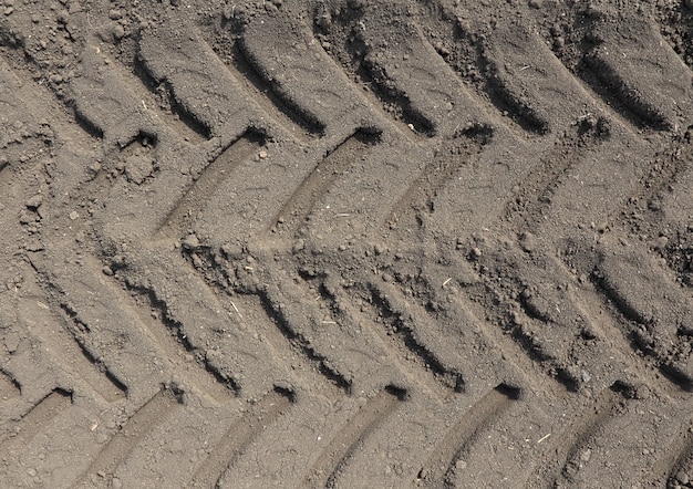 Photo tyre tread pattern on the ground in the field.