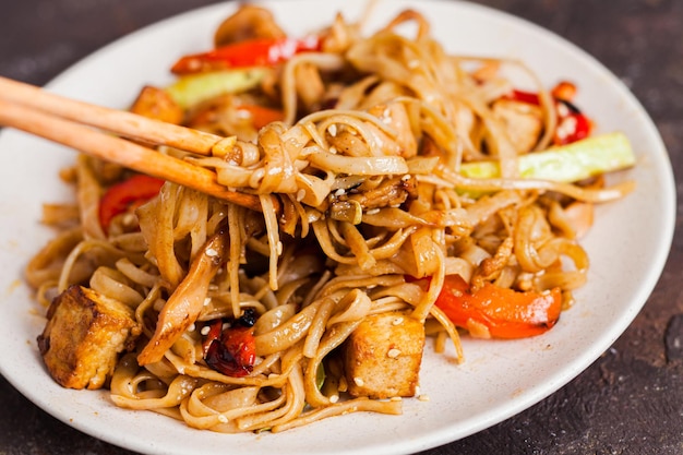 Udon noodles with tofu and vegetables Asian vegan vegetarian food meal stir fry in the plate