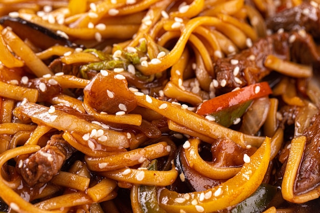 Udon noodles with vegetables and meat closeup