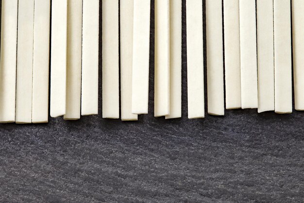 Udon raw uncooked strips flat noodles on slate stone plate dark selective focus