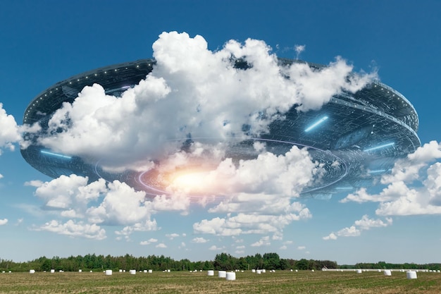 UFO an alien saucer hovering above the field in the clouds hovering motionless in the sky Unidentified flying object alien invasion extraterrestrial life space travel spaceship mixed media