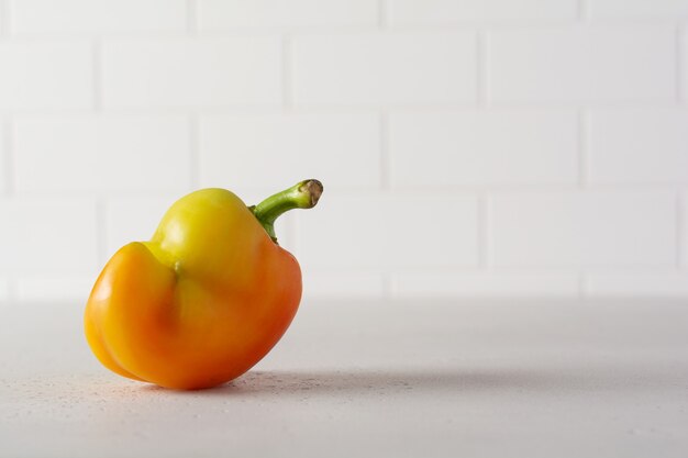 Ugly pepper that looks like a strange face on a light table. Funny, unnormal vegetable or food waste concept.