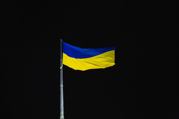 Ukraine blue and yellowflag fluttering in the wind against night sky National Ukrainian symbol