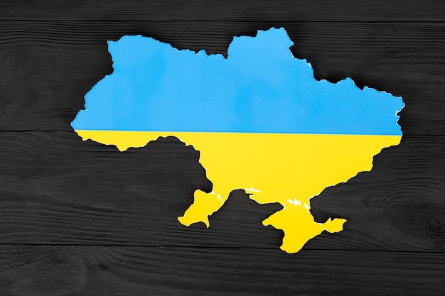 Ukraine cut out of paper on a blue and yellow background