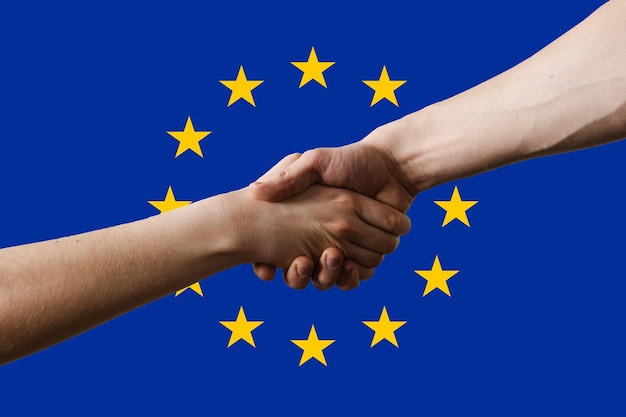 Ukraine and European union EU shaking hands each others on EU blue flag with stars background