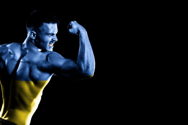 Ukraine flag on handsome young muscular man black background