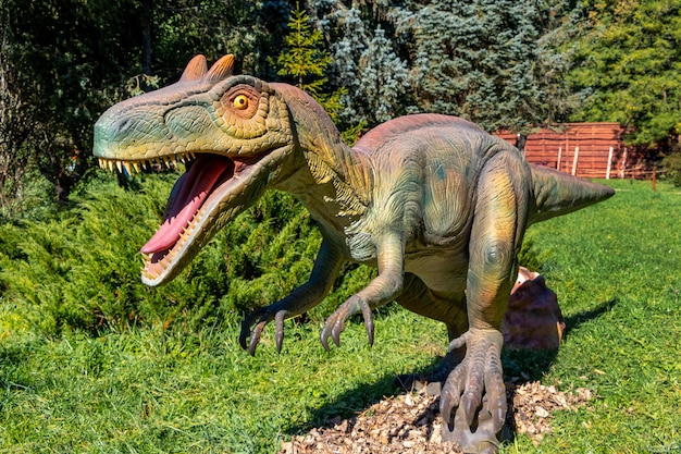 Ukraine, Khmelnitsky, October 2021. Dinosaur model in the park. Giant megaraptor at an exhibition in the park on a summer sunny day