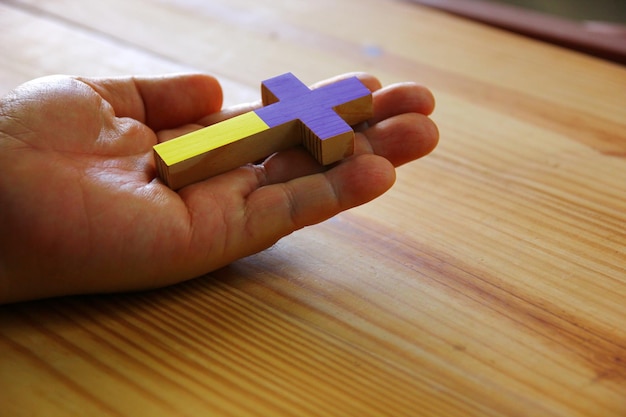 The Ukraine national flag color on wood cross on hand save Ukraine war concept