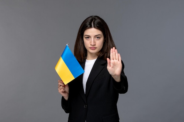 Ukraine russian conflict brunette pretty cute girl in black blazer saying to stop with flag