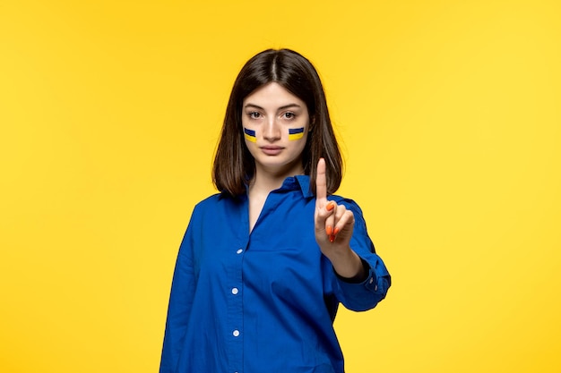 Ukraine russian conflict cute young girl in blue shirt yellow background stop the war