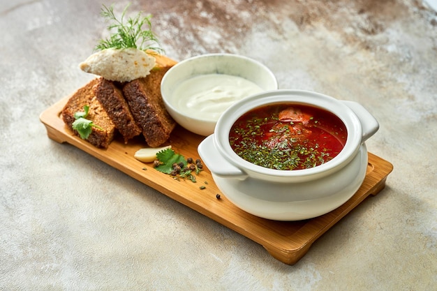 Ukrainian borscht with lard and bread, sour cream in a plate. Close-up, selective focus