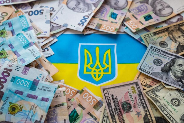 Ukrainian currency hryvnia and American dollar on the background of the Ukrainian flag State assistance to citizens in connection with the war in Ukraine