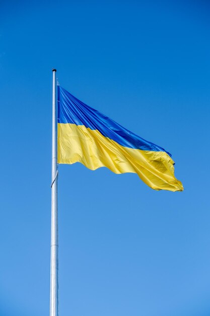 Ukrainian flag in the wind on blue sky background large national yellow blue flag of ukraine big