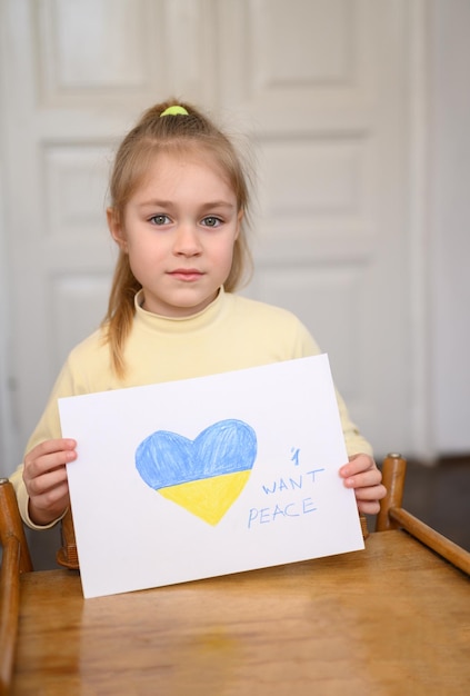 Ukrainian girl kid hands protesting against war conflict and holding message text I want peace