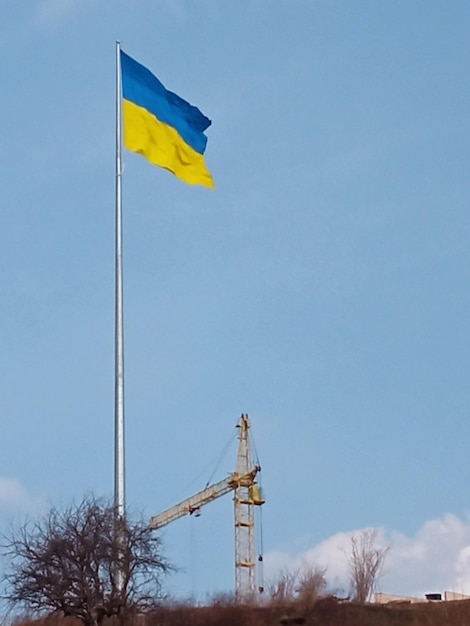 Ukrainian national flag symbol fluttering in blue sky Large yellowblue Ukrainian state flag