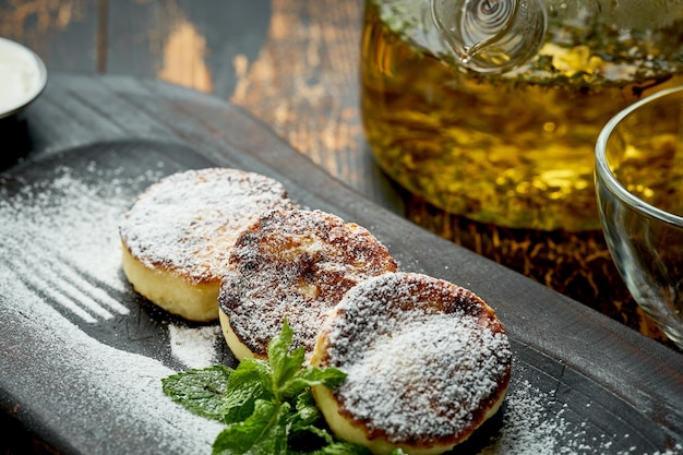 Ukrainian syrnyky on a wooden board on a wooden background rustic style fried cheese pancakes