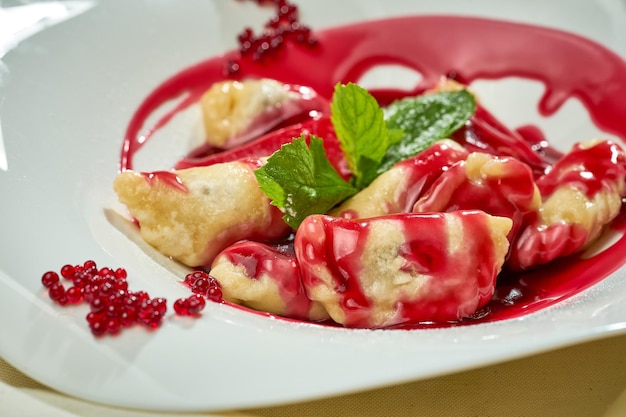 Ukrainian varenyky with cherries in a white plate of white tablecloth Hard light Selective focus