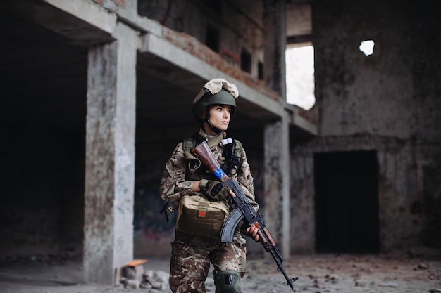 Ukrainian Woman Soldier with a weapon in his hands in a destroyed building War between Ukraine and Russia