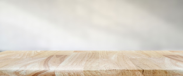 ultra wide product display with smooth wooden table and shadow wall