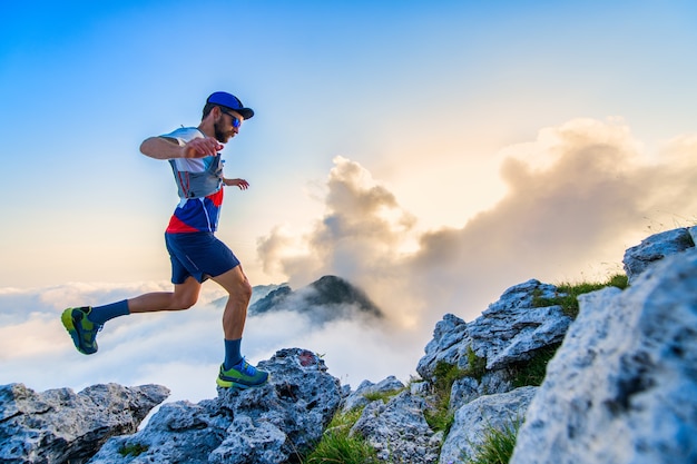 Ultramarathon runner in the mountains training at sunset