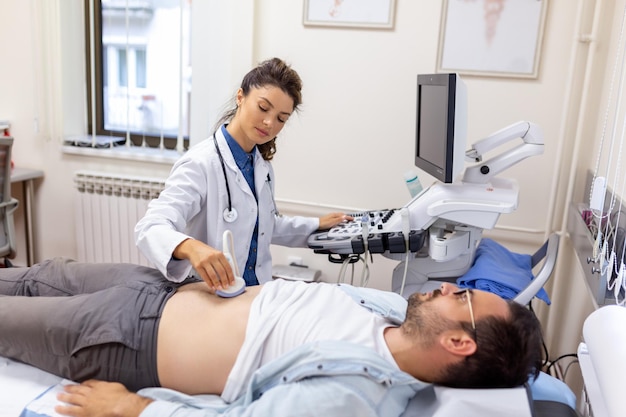 Ultrasound diagnosis of the stomach on the abdominal cavity of a man in the clinic closeup view The doctor runs an ultrasound sensor over the patient's male abdomen Diagnostics of internal organs