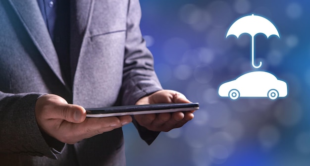 Umbrella and car icons Car insurance Man holding a tablet in his hand