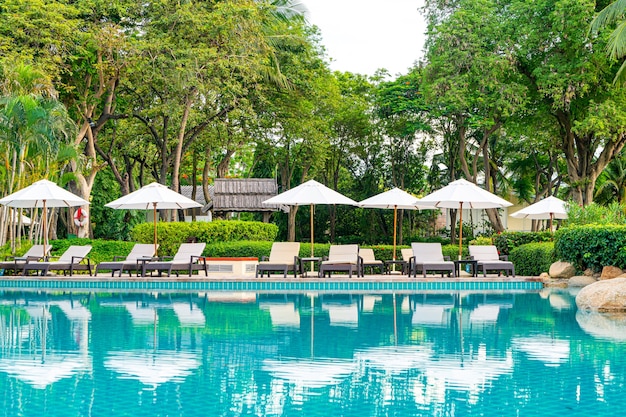 Umbrella and chair around swimming pool in hotel resort, holiday and vacation concept