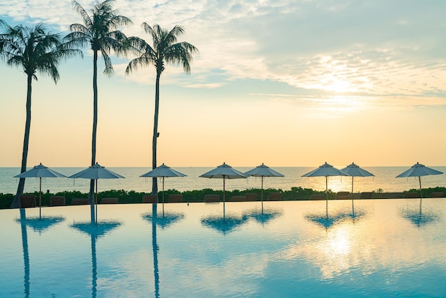 Umbrella with bed pool around swimming pool with ocean sea background